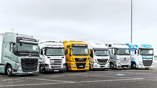 fleet of modern white freight trucks lined up at a European logistics company headquarters